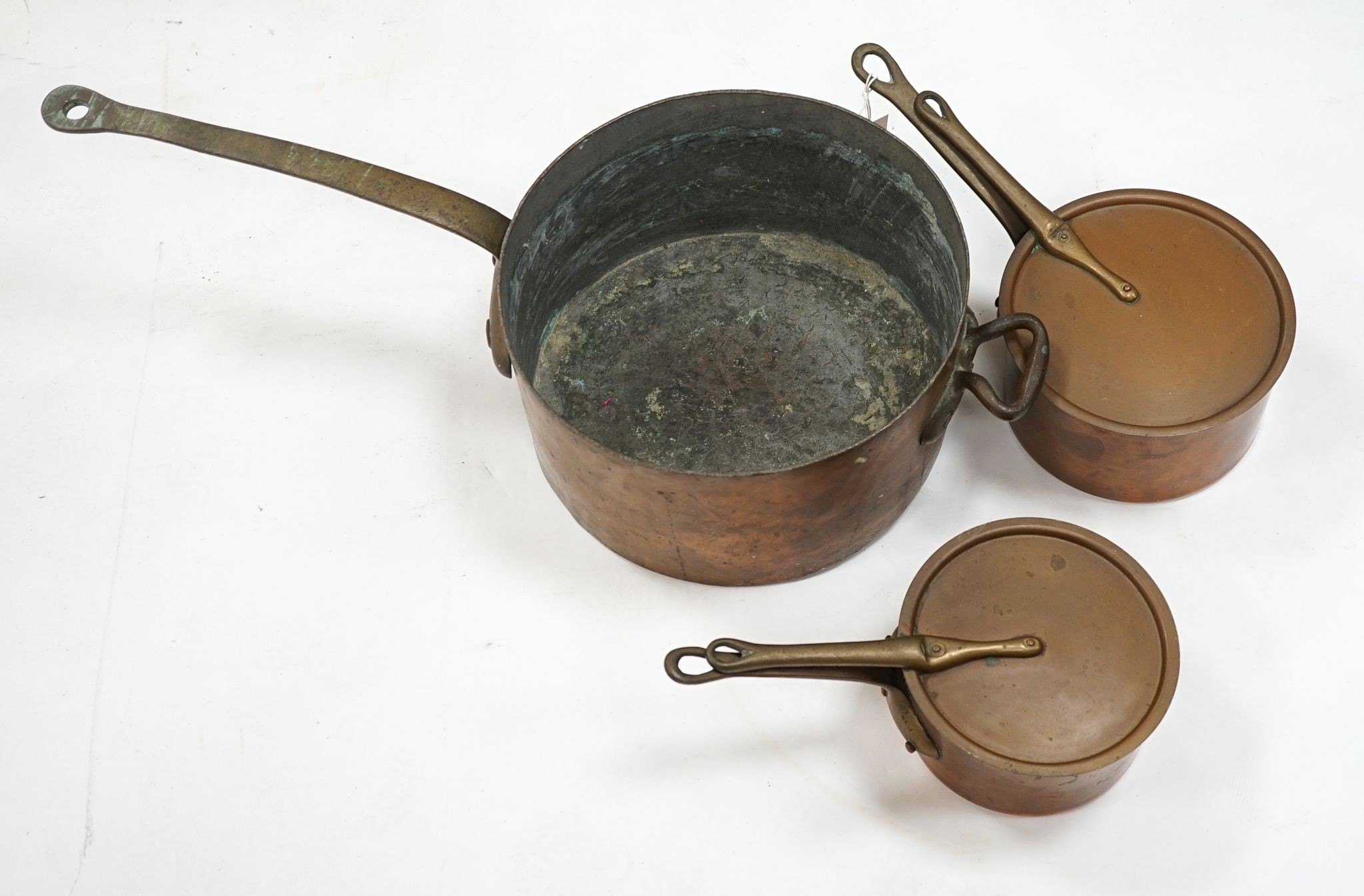 A group of three Jaeggi & Sons copper saucepans